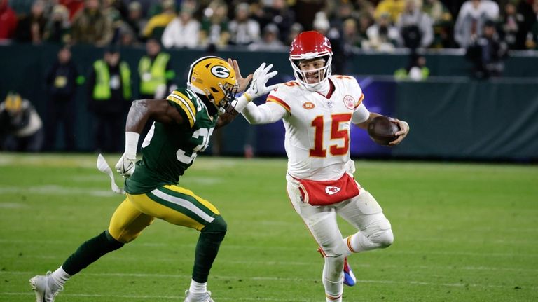 Kansas City Chiefs quarterback Patrick Mahomes (15) stiff arms Green...