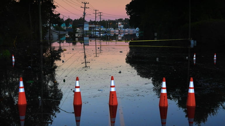 A street remains flooded at sunrise Wednesday in Fayetteville, N.C.,...