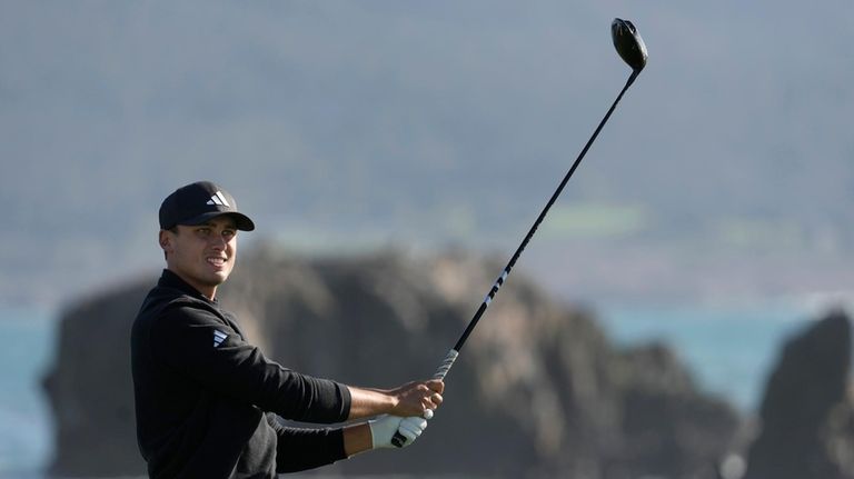 Ludvig Åberg watches his shot from the 18th tee at...