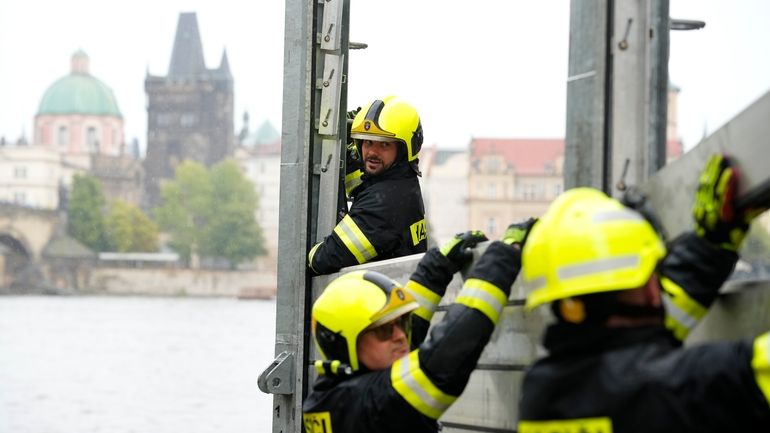 Firefighters adjust parts of the anti-flood barriers in Prague, Czech...