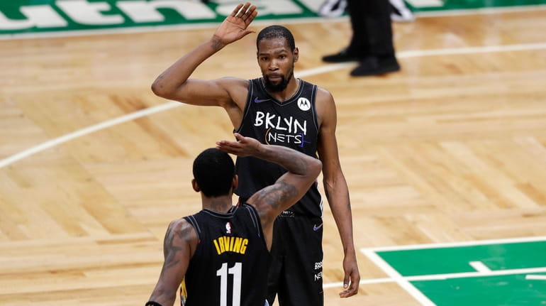 Kevin Durant and Kyrie Irving of the Nets high-five during the fourth...