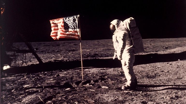 Edwin E. "Buzz" Aldrin Jr. near the flag U.S. astronauts...