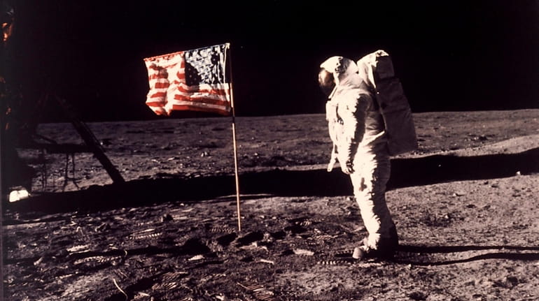 Edwin E. "Buzz" Aldrin Jr. near the flag U.S. astronauts...