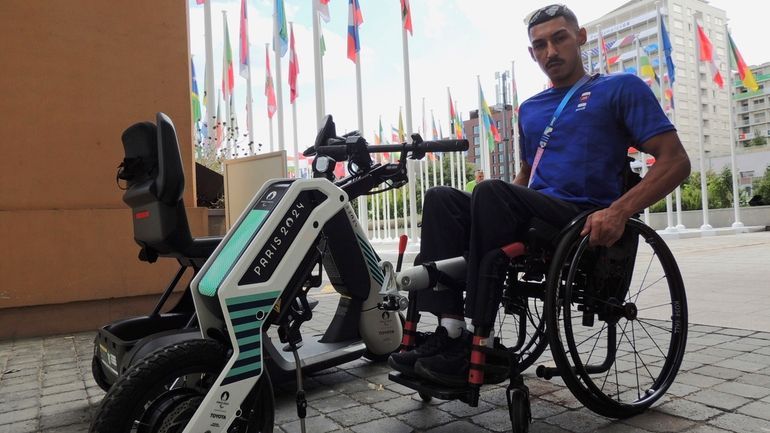 Qatari para-athlete Ali Radi Arshid poses near a motorized device...