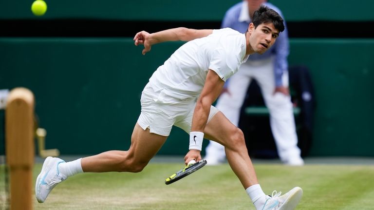 Carlos Alcaraz of Spain plays a backhand return to Daniil...