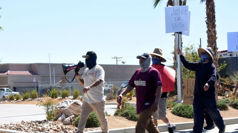 Los Angeles-based activist Edin Enamorado, holding a megaphone, leads a...