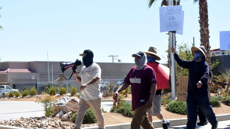 Los Angeles-based activist Edin Enamorado, holding a megaphone, leads a...