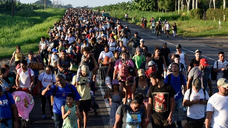 Migrants walk along the highway through Suchiate, Chiapas state in...