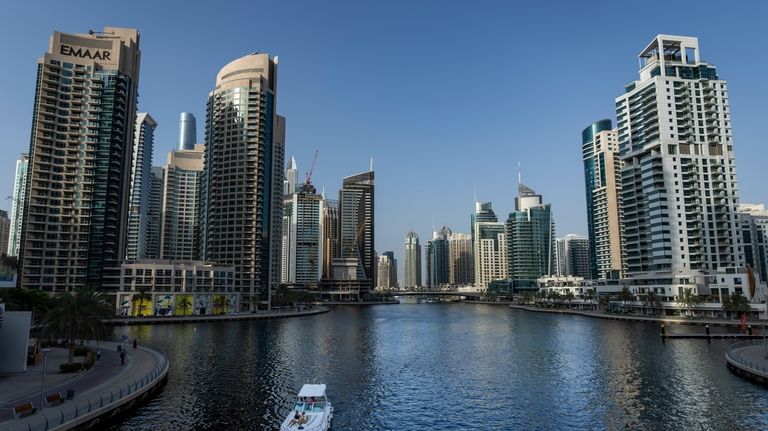 People sit on a boat as it sails along Dubai...