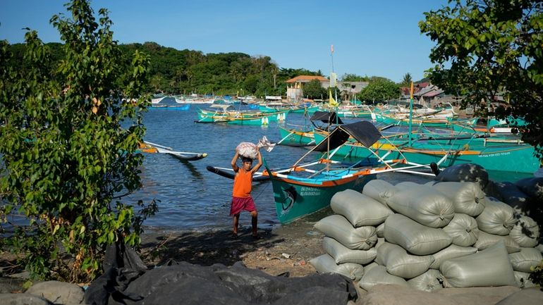 A resident brings down a sack from his boat at...