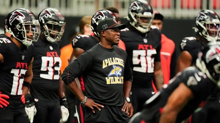 Atlanta Falcons head coach Raheem Morris, center, stands with his...