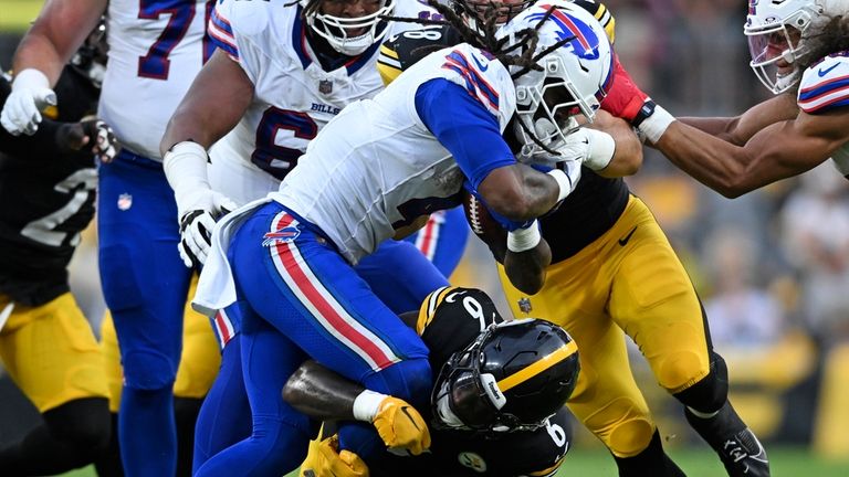 Buffalo Bills running back James Cook (4) is tackled by...