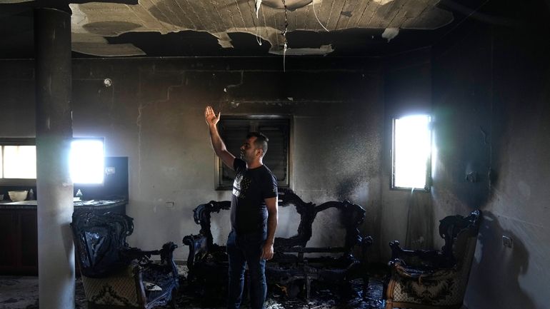 A Palestinian stands in his home the morning after it...