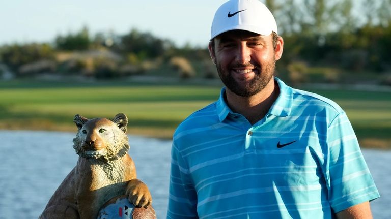 Scottie Scheffler, of the United States, poses with the winner's...