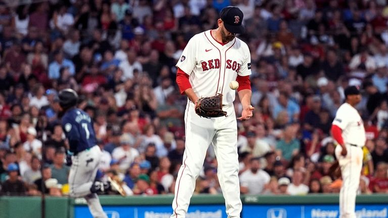 Boston Red Sox pitcher James Paxton looks down at a...