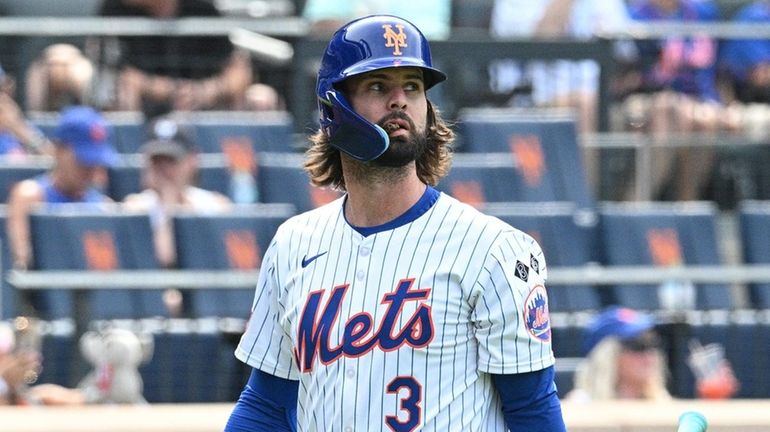 Mets' Jesse Winker returns to the dugout after striking out...