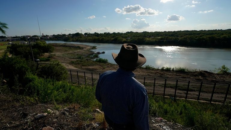 Kayak outfitter Jessie Fuentes stands above the Rio Grande in...