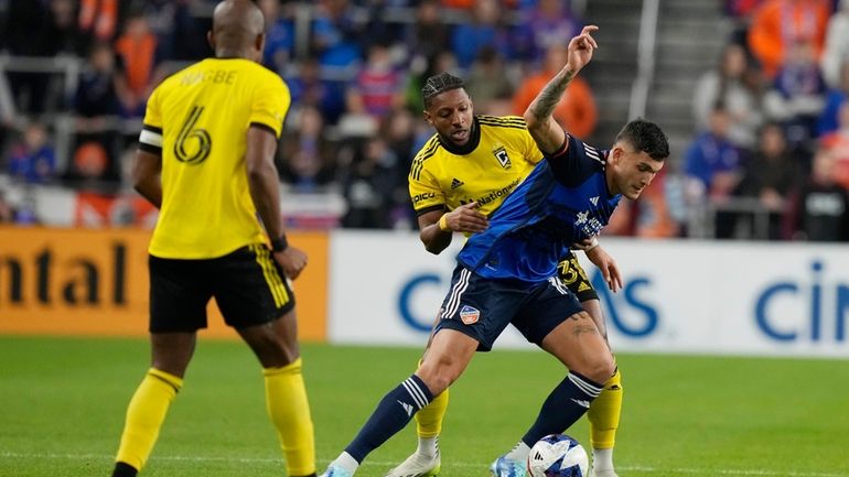 Columbus Crew defender Steven Moreira, rear, and FC Cincinnati forward...