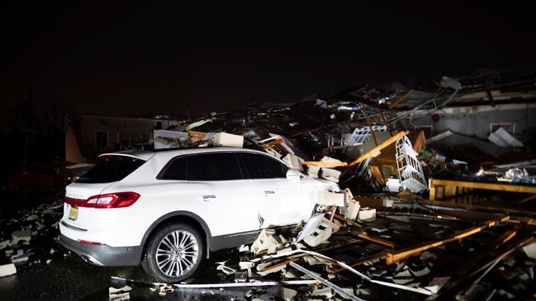 A car is buried under rubble on Main Street after...