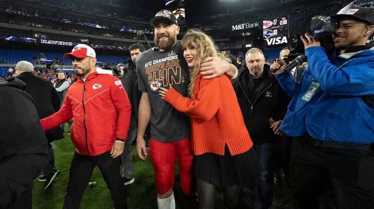 Kansas City Chiefs tight end Travis Kelce walks with Taylor...