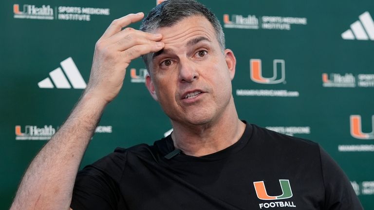 Miami head coach Mario Cristobal speaks with the media following...