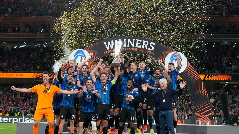 Atalanta's players celebrate with the trophy after winning the Europa...