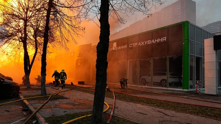 Firefighters work to extinguish a fire in a destroyed building...