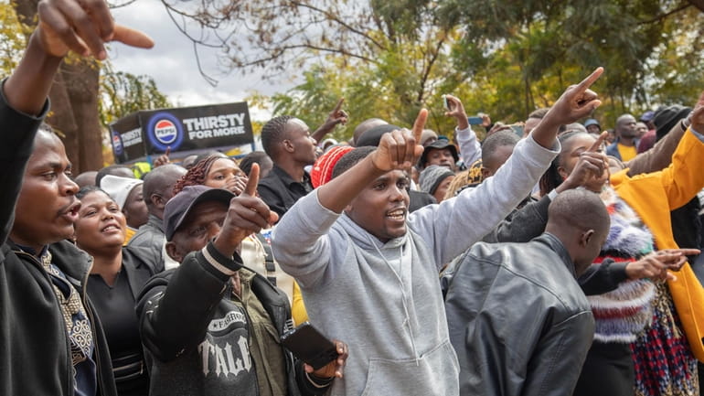 Opposition supporters protest outside a court, in Harare, Zimbabwe, Thursday,...