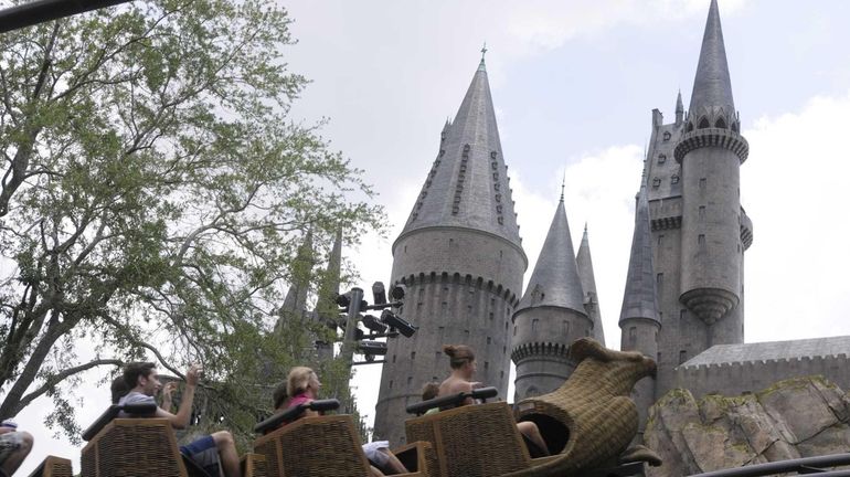 Guests ride on the Flight of the Hippogriff past Hogwarts...