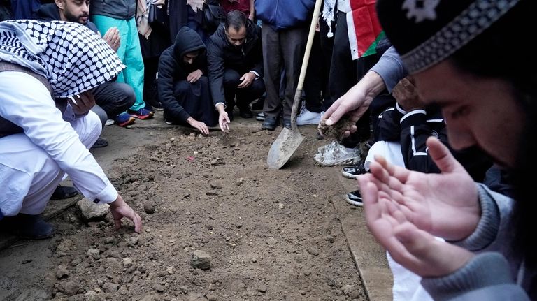 Muslim community members mourn Wadea Al Fayoume at his grave...