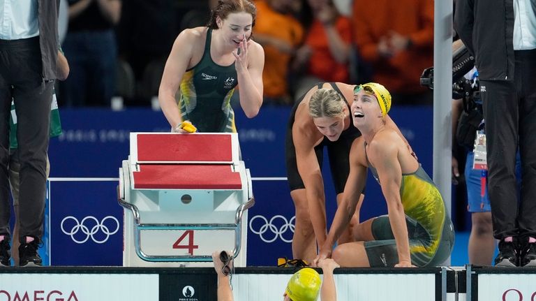 Swimmers from Australia celebrate after winning the women's 4x100-meter freestyle...