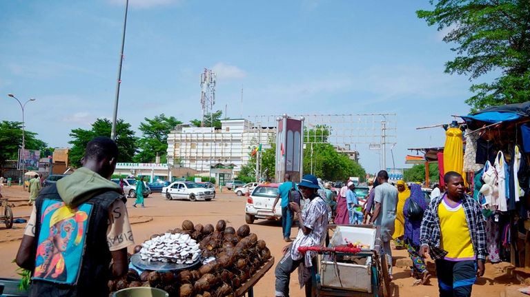 A man sells coconuts on the street in Niamey, Niger,...