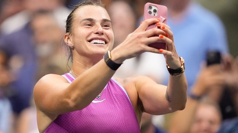 Aryna Sabalenka, of Belarus, records images after defeating Jessica Pegula,...