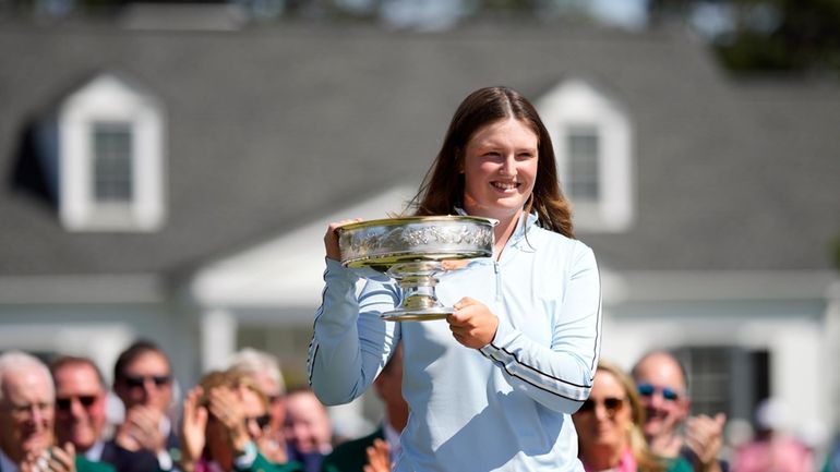 Lottie Woad, of England, poses with the trophy for photographers...