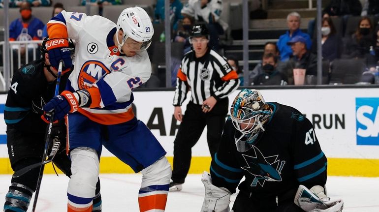 Sharks defenseman Marc-Edouard Vlasic, left, looks for the puck as...