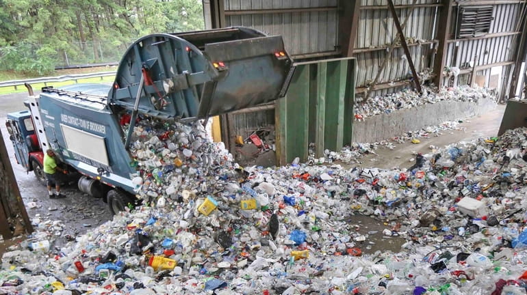 A truck dumps its contents of recyclable items on the...