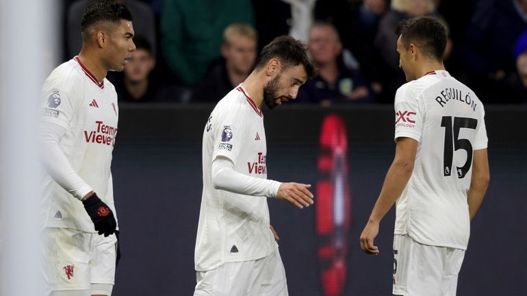 Manchester United's Bruno Fernandes, center, celebrates with teammates after scoring...