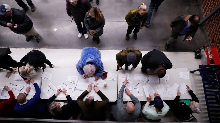 Caucus goers check in at a caucus at Roosevelt Hight...