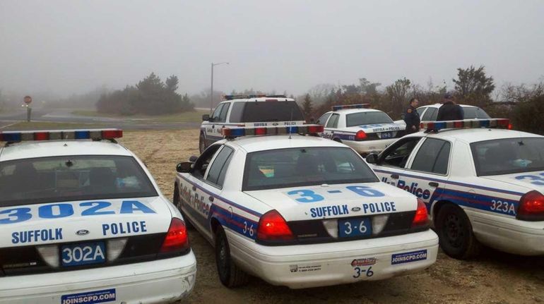 Officers from the Suffolk County Police Department gather in the...