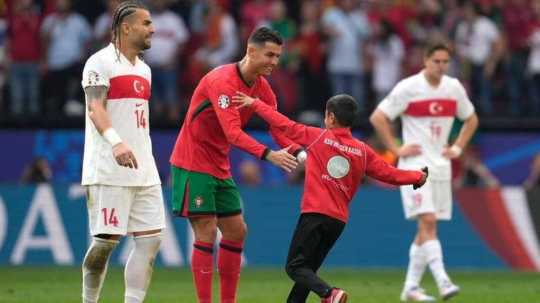 A young pitch invader goes to Portugal's Cristiano Ronaldo during...