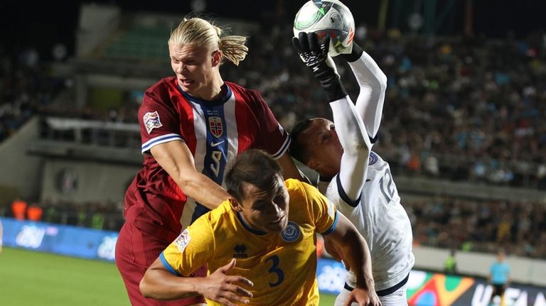 Kazakhstan's goalkeeper Igor Shatskiy, right, and Nuraly Alip, center, fight...