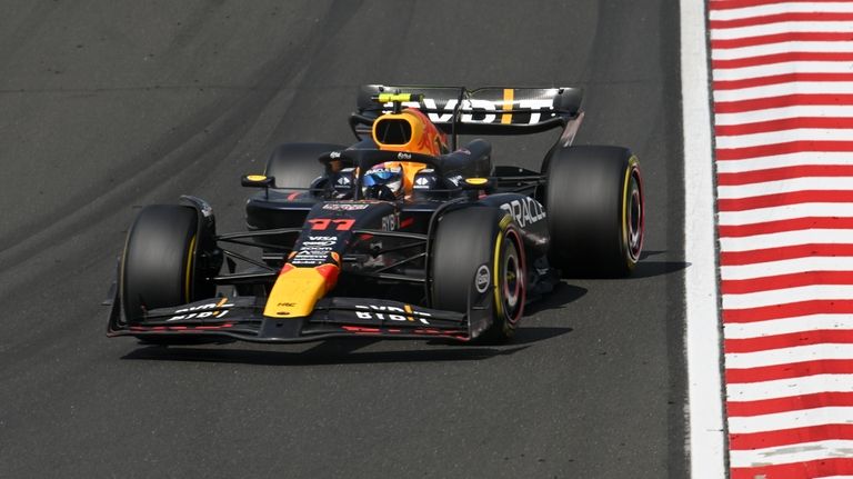 Red Bull driver Sergio Perez of Mexico steers his car...