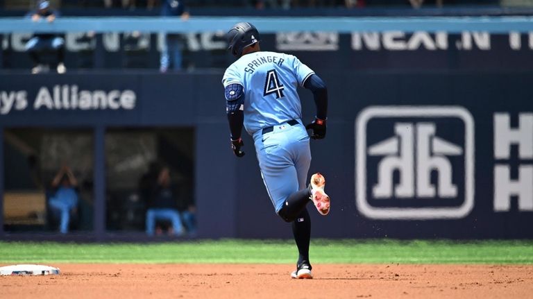 Toronto Blue Jays' George Springer runs the bases after hitting...