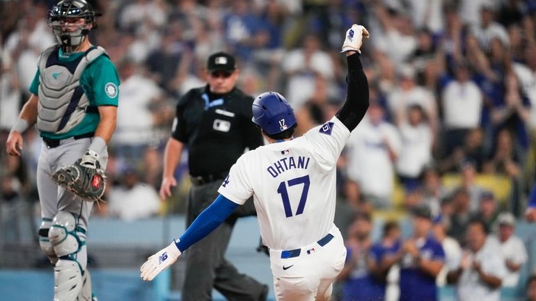 Los Angeles Dodgers designated hitter Shohei Ohtani scores off of...