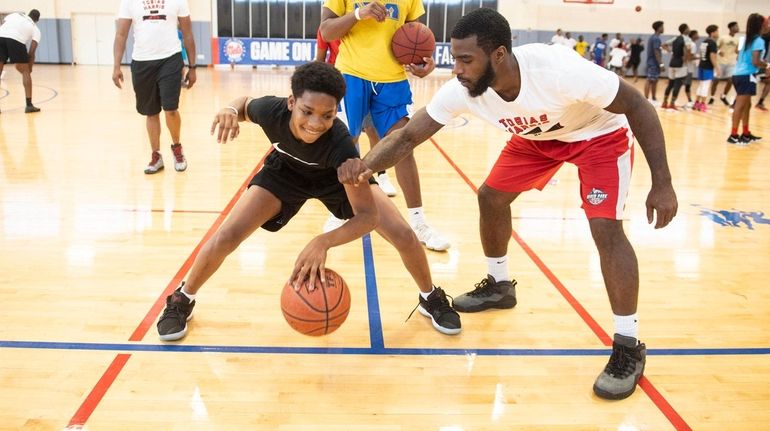 Tariq Summers, 15, left, with coach Devon McMillan as he...