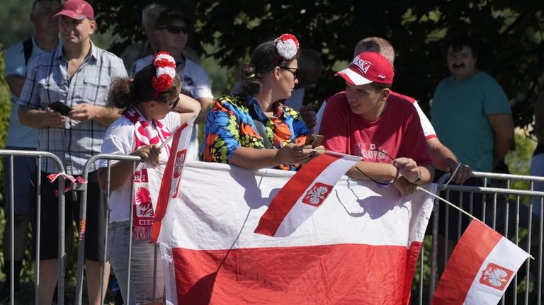 People wait for a massive military parade during the Polish...