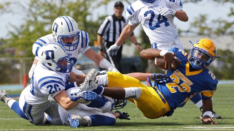 Chris Collier #22 of the Lawrence Golden Tornadoes gets tangled...