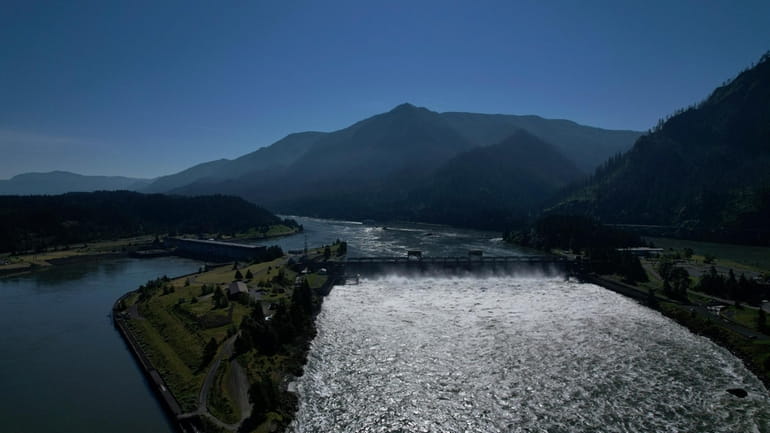 Water spills over the Bonneville Dam on the Columbia River,...