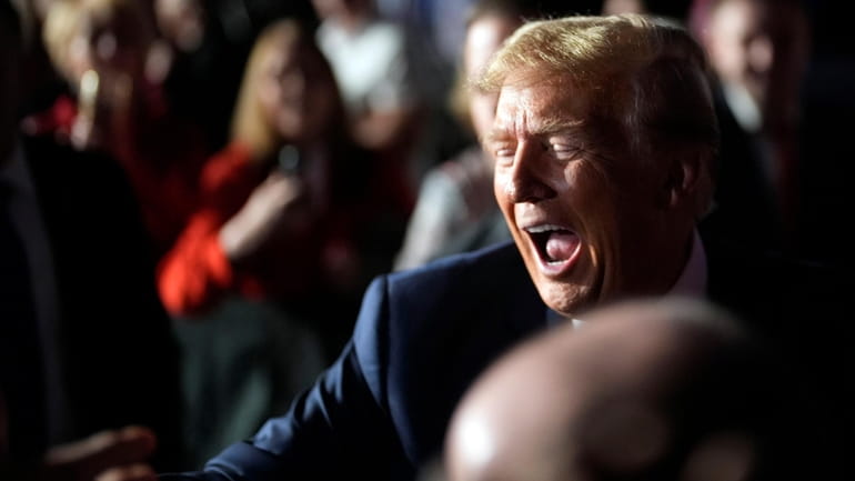 Republican presidential candidate former President Donald Trump greets people after...