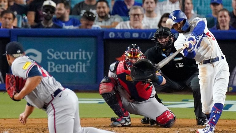 Los Angeles Dodgers' Mookie Betts, right, hits a solo home...